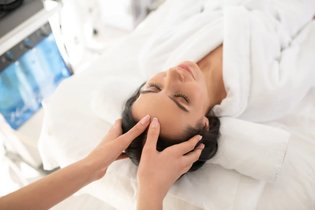 alumna de estética realizando masaje facial