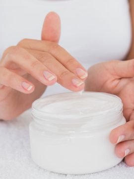 Mujer cogiendo crema de un bote